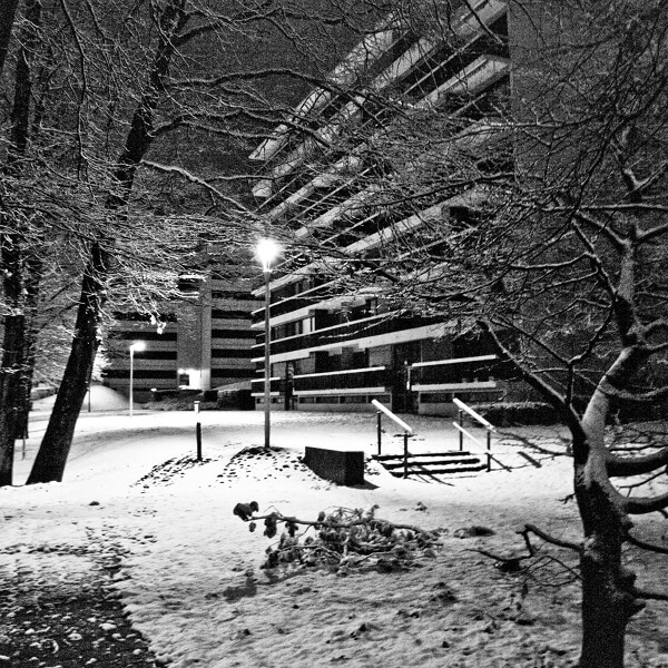 Une rue d'une ville la nuit sous la neige.